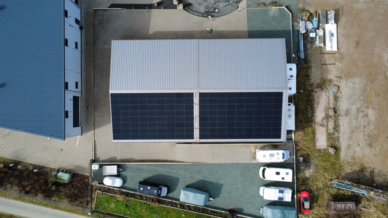 Gewerbehalle mit vollflächig belegter Photovoltaik-Dachanlage, Luftaufnahme