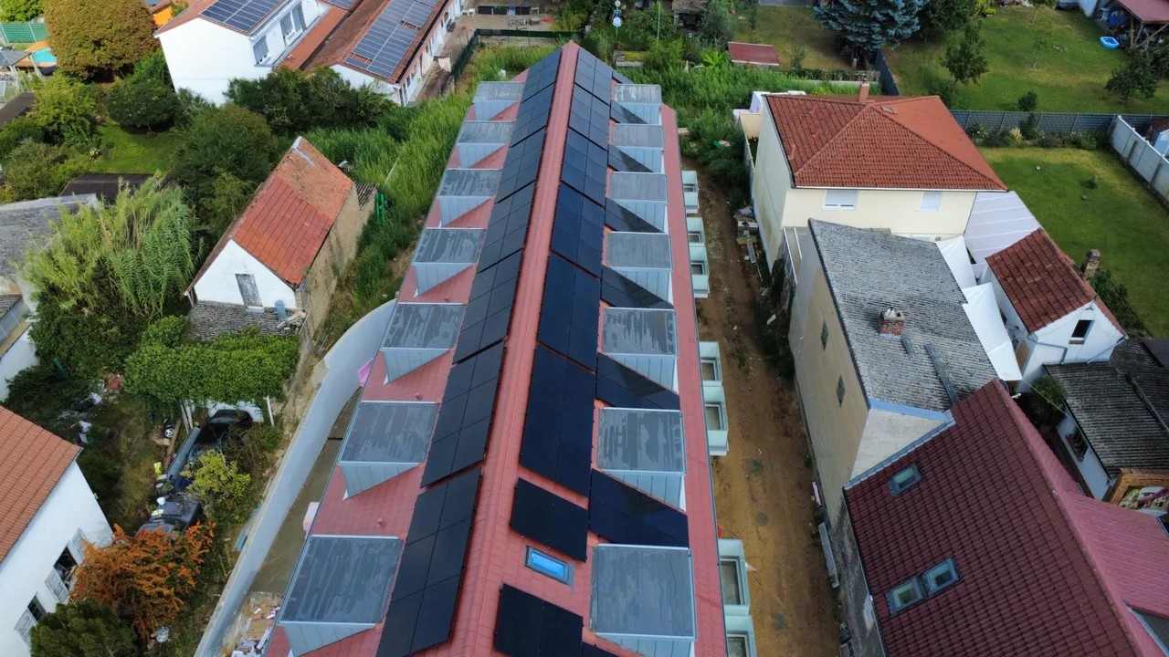 Mehrfamilienhaus mit Photovoltaikanlage auf beiden Dachseiten, Drohnenaufnahme